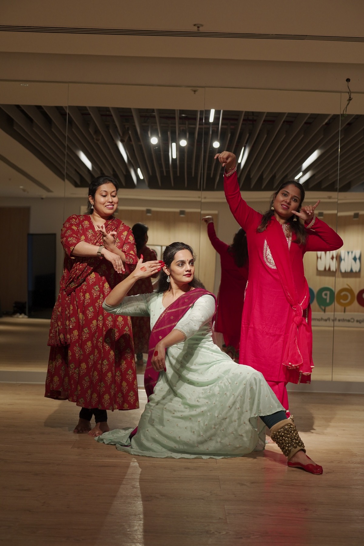 Three dancers sharing a Kathak pose.